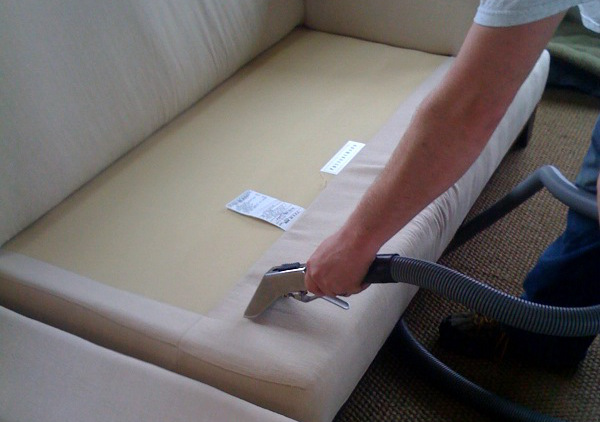 Photo of sofa with cushions removed being cleaned